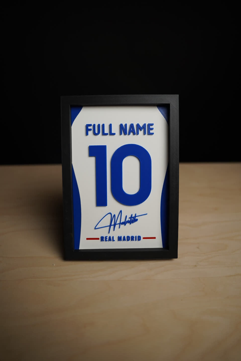 Real Madrid jersey frame on a desk, shown with sample name and number